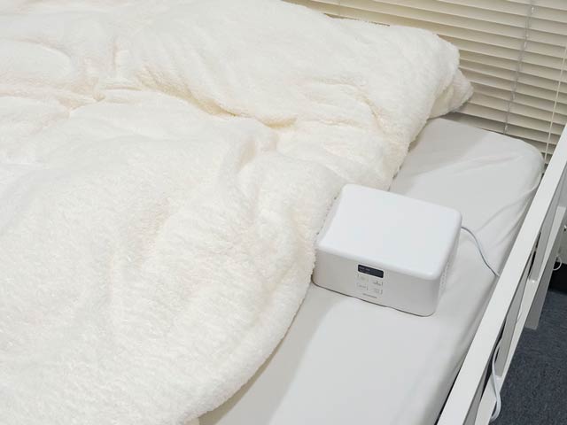 ホースが隠れるように布団をかぶせる