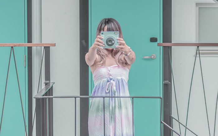 インスタントカメラを持って撮影している姿